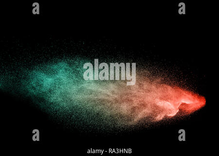 Multi color particles explosion on black background. Colorful dust splatter on dark background. Stock Photo