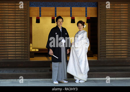 Bride and groom in traditional dressess posing in the Meiji Jingu Shinto Shrine Stock Photo