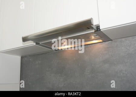 Cooker Hood. Modern air exhauster kitchen fan or range hood. Stainless steel chimney hood. Island hood. Stock Photo