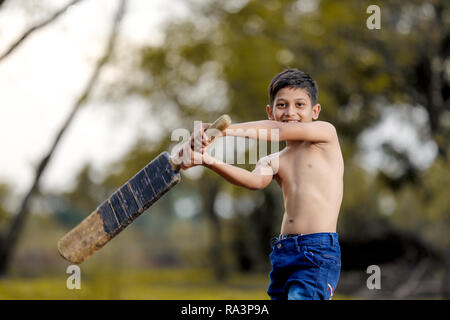 Rural Indian Child Playing Cricket Stock Photo