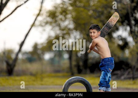 Rural Indian Child Playing Cricket Stock Photo