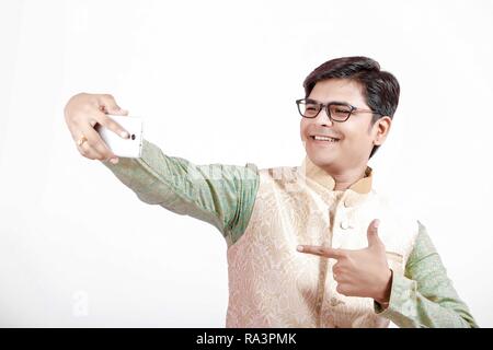 young Indian man taking selfie with mobile Stock Photo