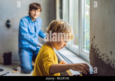 Father and son repair windows together. Repair the house yourself Stock Photo