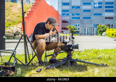 Shooting process on cinema stage - commercial production set, exterior location.Profeccional cameraman operates the camera Stock Photo