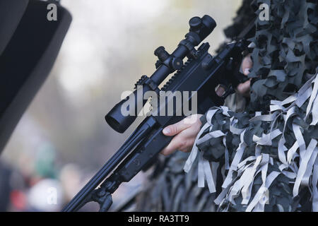 Details with the hands of an army sniper holding his rifle Stock Photo