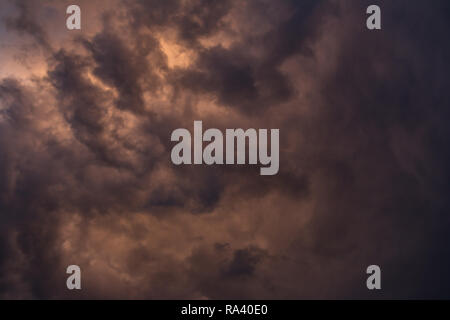Dramatic stormy clouds with orange hue Stock Photo