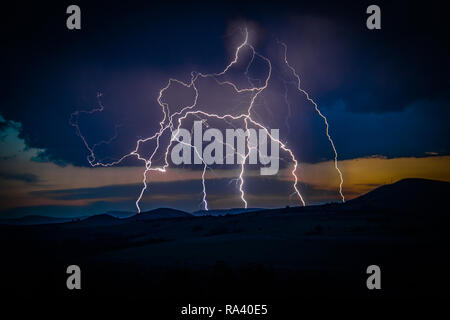 Multiple lightning strikes on distant mountain Stock Photo