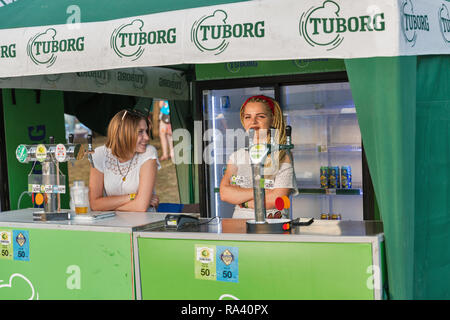 KIEV, UKRAINE - JULY 08, 2018: Young woman bartenders work in Tuborg beer outdoor bar at the Atlas Weekend Festival in National Expocenter. Tuborg is  Stock Photo