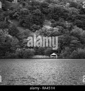 Looking across Rydal Water towards the old boathouse with the backdrop of trees on the hillside filling the frame Stock Photo