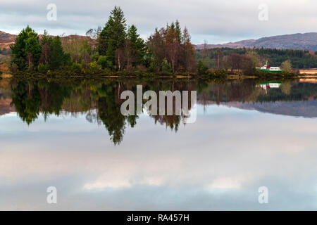 The M.V. Sileas and trees reflected in Loch Sheil, Argyll, Scotland. Stock Photo