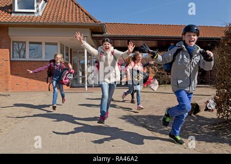 Students after school, start of vacacions, running out of school, primary school, Lower Saxony, Germany Stock Photo