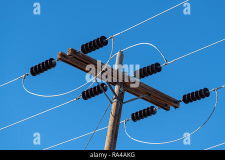 Power lines and insulators with a clear blue sky Stock Photo