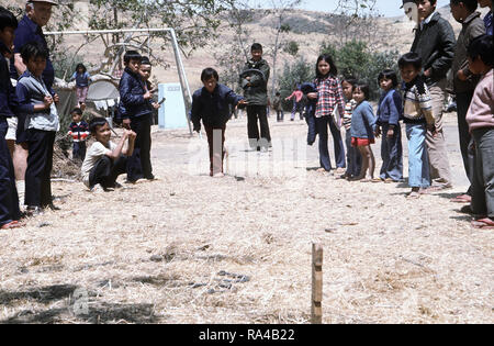 1975 - Children play at horseshoes at a temporary housing facility for Vietnamese refugees. Stock Photo