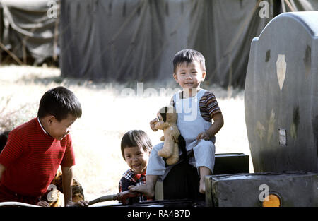 1975 - Children play on a piece of equipment at a temporary housing facility for Vietnamese refugees at Camp Pendleton Stock Photo