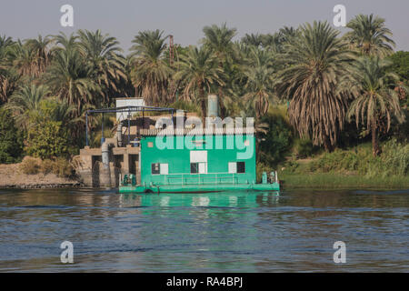 View across river Nile in Egypt through rural landscape with large irrigation water pumping station Stock Photo