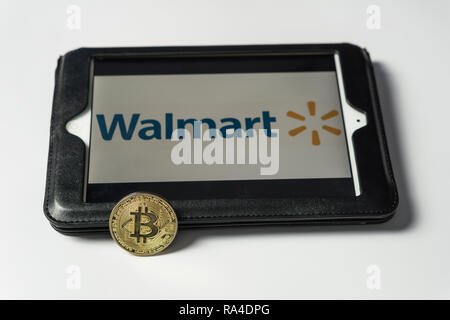 Bitcoin coin with the Walmart logo on a computer tablet screen, Slovenia - December 23th, 2018 Stock Photo