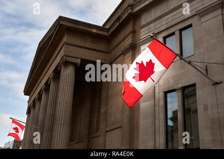 The red and white maple leaf flag flies outside Canada House, home of the High Commission of Canada, Trafalgar Square, London, England. Stock Photo