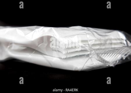 Bulk packing of plastic cutlery, disposable cutlery, forks, plastic waste Stock Photo