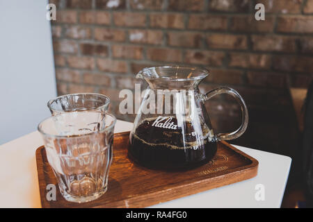 Fresh filtered coffee in kalita glass in a vintage cafe with bricks