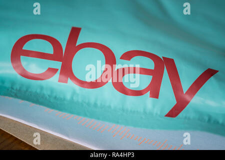 An Ebay delivery package resting on the floor along with letters received in the mail. Stock Photo