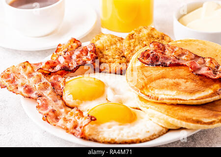 Healthy Full American Breakfast with Eggs Bacon Pancakes and Latkes, selective focus. Stock Photo