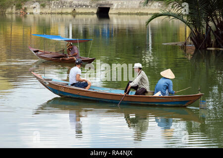 Everyday life scene of local men fishing for food in small traditional boat on Thu Bon River. Hoi An, Quang Nam Province, Vietnam, Asia Stock Photo