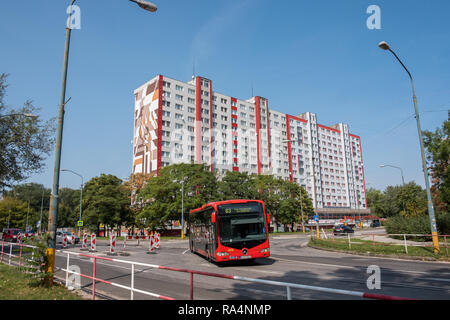 Petrzalka, Slovakia- The apartment building from the socialist era of Bratislava suburbs still being used and maintained with bus passing by Stock Photo