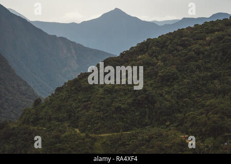 View of the Yungas Road or Death Road winding through steep forested mountains in Bolivia, South America Stock Photo