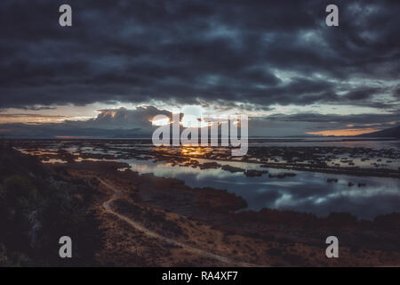 Picturesque sunrise over lake Titicaca in Peru with dark sky reflecting in calm water surface Stock Photo