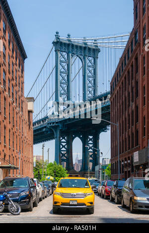 New York, USA - May 26, 2018: Yellow cab on a street in Dumbo of New York City. It is a major attraction in New York with view of Manhattan Bridge. Stock Photo