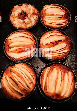 Small homemade apple pies freshly baked each in its mold Stock Photo