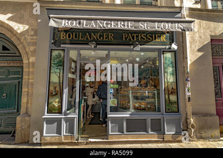 People buying bread in Boulangerie St Louis ,a bakery and pattissier  on Rue Saint-Louis en l'Île ,Paris,France Stock Photo