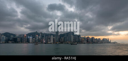 The sun sets over Kennedy Town and Green Island in the west of Hong Kong Island, as the city lights up for the night Stock Photo