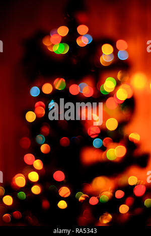 a bokeh of blue, green and yellow in the background, a new Christmas tree is blurred 2018 Stock Photo