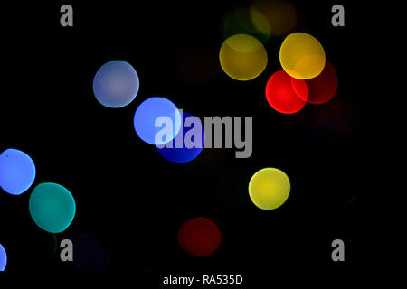 bokeh blue, green, yellow, red tones on black background on New Year's Eve 2018 Stock Photo