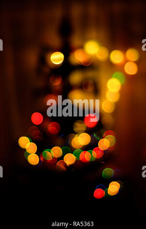 A colored bokeh in the background blurs a Christmas tree 2018 Stock Photo