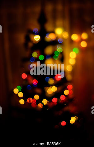 A colored bokeh in the background blurs a Christmas tree 2018 Stock Photo
