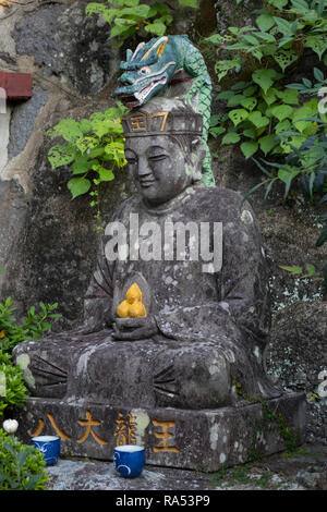 Nagasaki, Japan - October 24, 2018: Smiling old stone buddha statue at the Kofukuji temple grounds Stock Photo