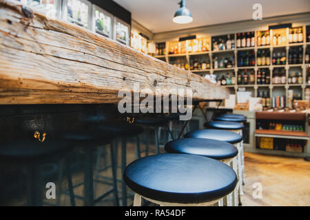 Close up of black stools chairs row at the wooden bar, no people focus on foreground Stock Photo