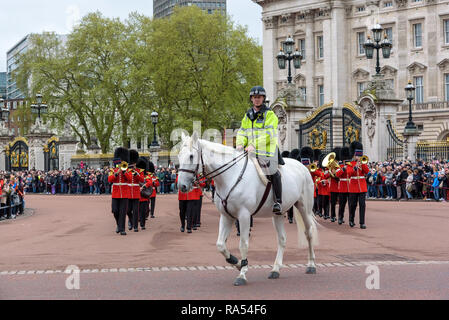 London, UK - April 29, 2018: Mounted police officer leads marching Royal Guard soldiers during changing of the guard at Buckingham Palace Stock Photo