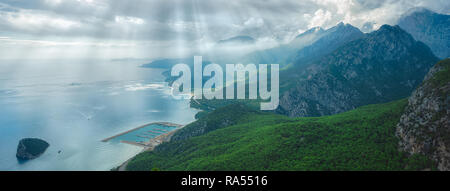 Aerial wide angle view of mountain panorama in Antalya city, Turkey, Sunny blue sky, white clouds, sunrays and sunbeams through clouds, sparkling blue Stock Photo