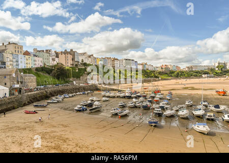 TENBY, PEMBROKESHIRE, WALES - AUGUST 2018: The harbour in Tenby, West Wales, at low tide with the town's multi coloured buildings in the background. Stock Photo