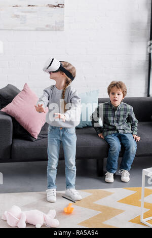 beautiful brother and sister using virtual reality headset at home Stock Photo
