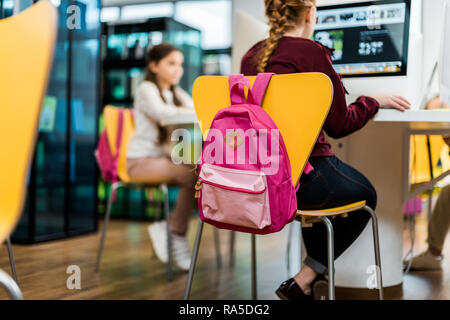 focused schoolgirls using desktop computers in library Stock Photo