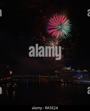 Colorful fireworks over the Danube in Bratislava at night, with Bratislava Castle illuminated on the skyline. Stock Photo