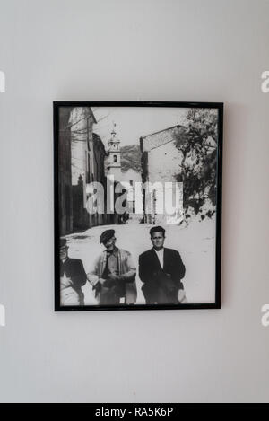 An old photograph hanging in a cafe of three men sat in the street in the village of Benisiva, Province of Alicante, Spain. Stock Photo