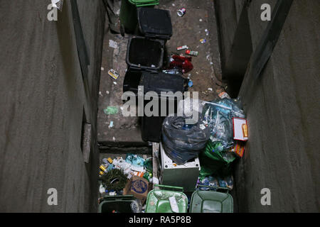 Bucharest, Romania - January 1, 2019: Full of garbage and very dirty dumpsters inside a tall block of flats in Bucharest. Stock Photo