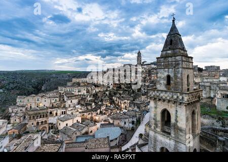Church tower of San Pietro Barisano in front of the old town with cathedral, cloudy sky, Matera, Basilicata, Italy Stock Photo