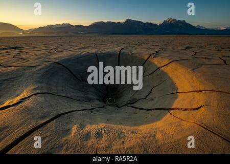 Cracky, dried out soil and Allgäu Alps in the background at sunrise, Forggensee, Füssen, Ostallgäu, Bavaria, Germany Stock Photo