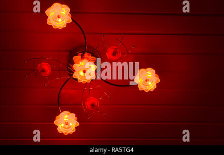 modern home interior background, a modern lamp decorated with flowers, shining red light in the dark Stock Photo